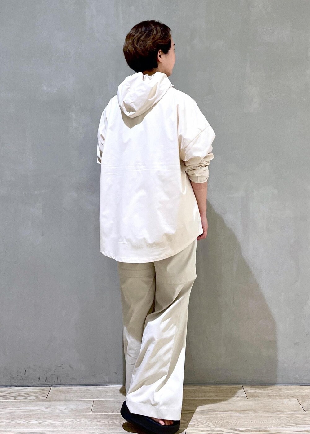 ホワイト系のパーカー、グレー系のその他パンツ、ブラック系のサンダルを着用したレディースの春コーディネートの2枚目の写真