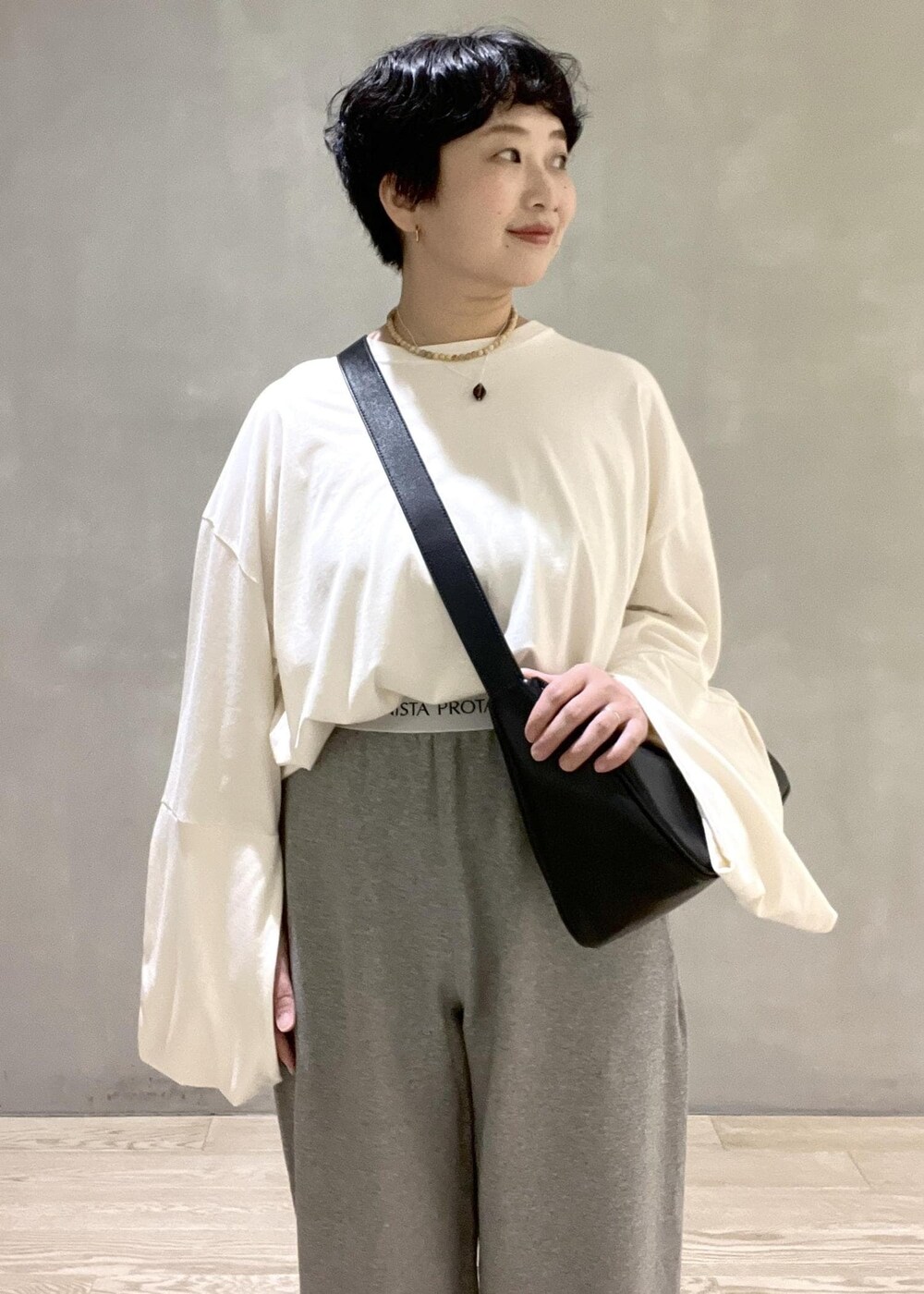 ブラック系のショルダーバッグ、ホワイト系のTシャツ/カットソー、ホワイト系のパンプスを着用したレディースの夏コーディネートの3枚目の写真