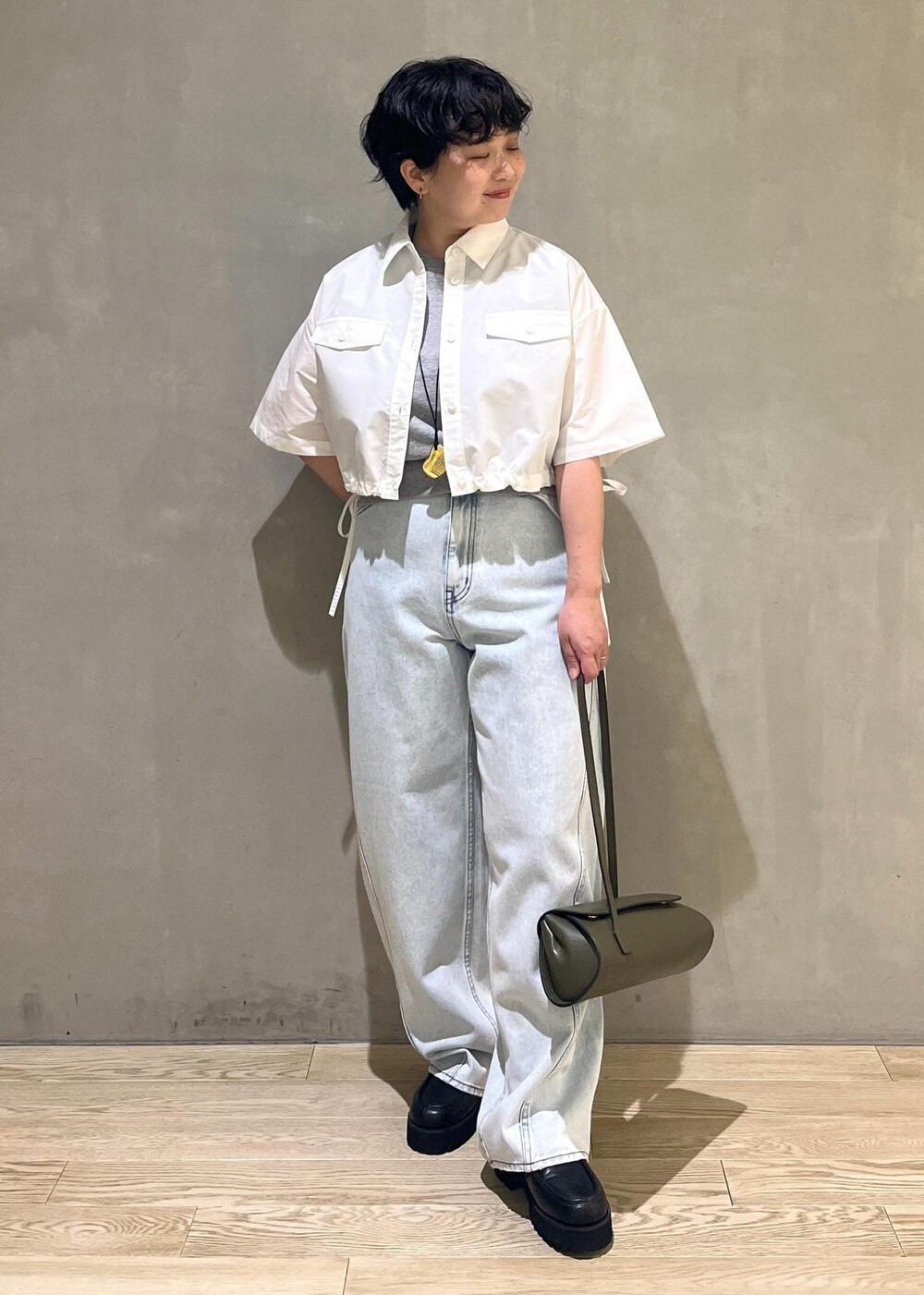 グレー系のTシャツ/カットソー、ブルー系のデニムパンツ、ホワイト系のシャツ/ブラウスを着用したレディースの夏コーディネートの5枚目の写真