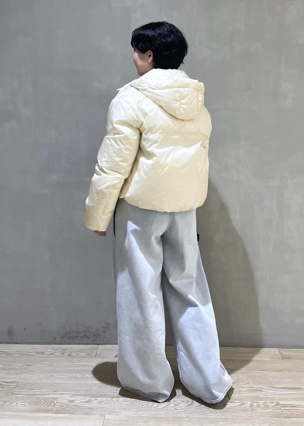 ベージュ系のトートバッグ、ブルー系のデニムパンツ、ブラウン系のスウェットを着用したレディースの秋コーディネートの4枚目の写真