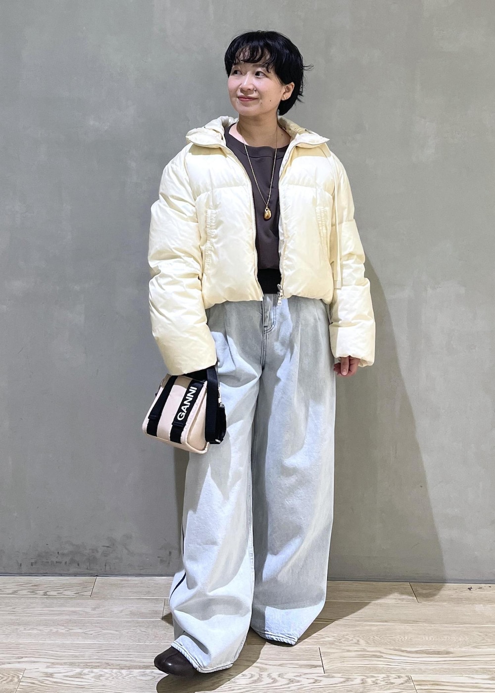 ベージュ系のトートバッグ、ブルー系のデニムパンツ、ブラウン系のスウェットを着用したレディースの秋コーディネートの6枚目の写真