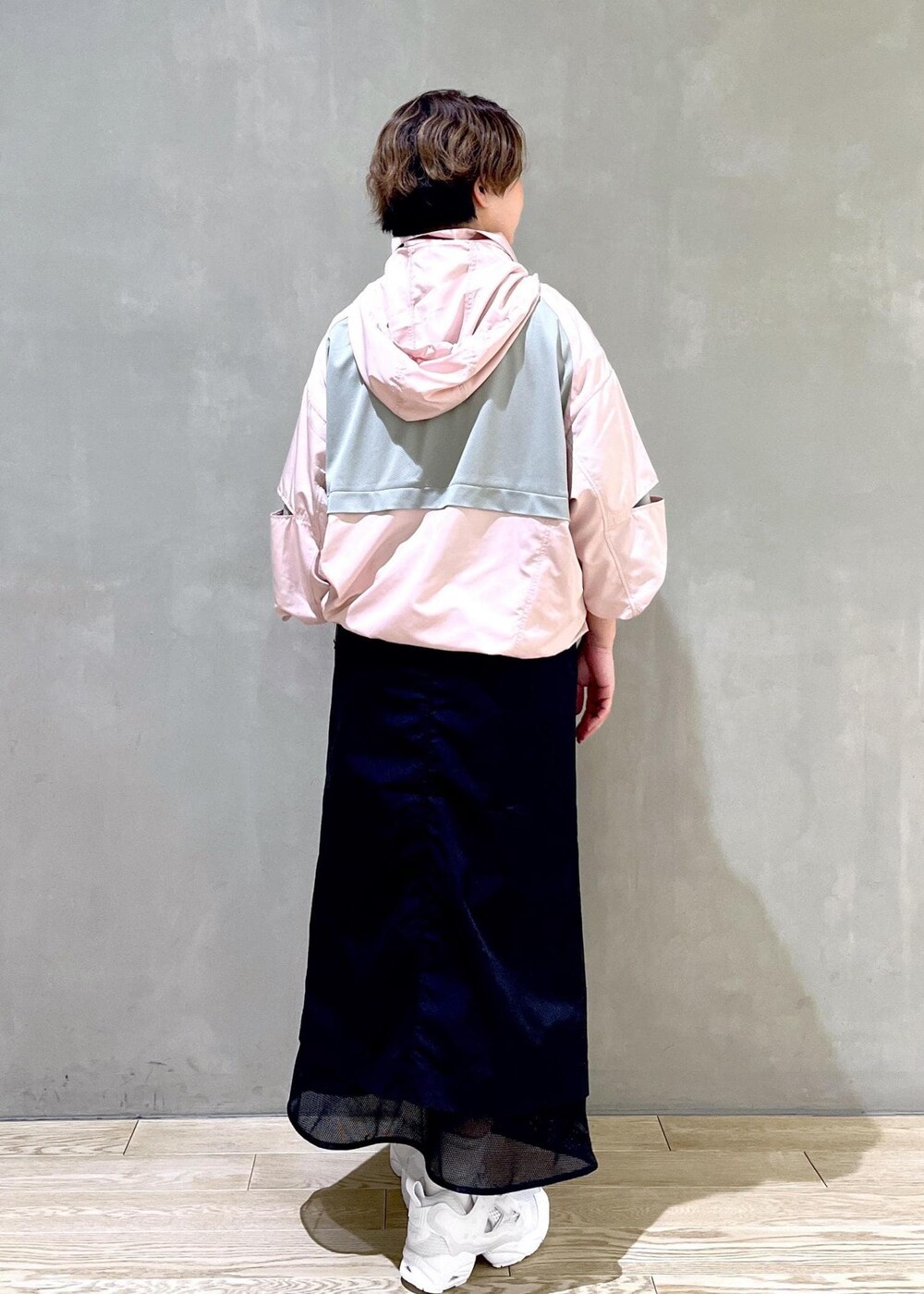 ホワイト系のスニーカー、ピンク系のブルゾン、ブラック系のスカートを着用したレディースの春コーディネートの3枚目の写真