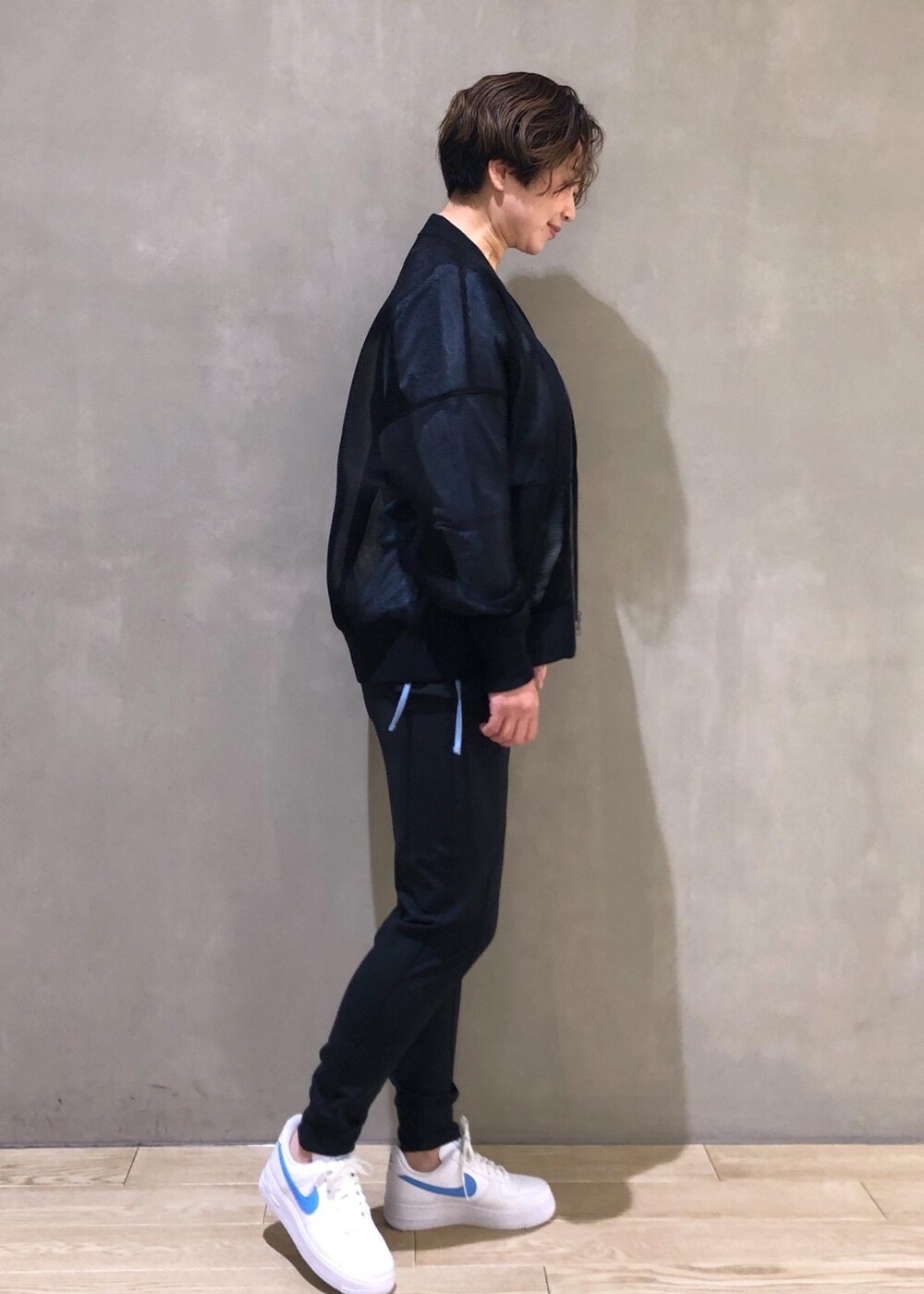 ブラック系のカーディガン/ボレロ、ブラック系のTシャツ/カットソー、ホワイト系のスニーカーを着用したレディースの冬コーディネートの3枚目の写真