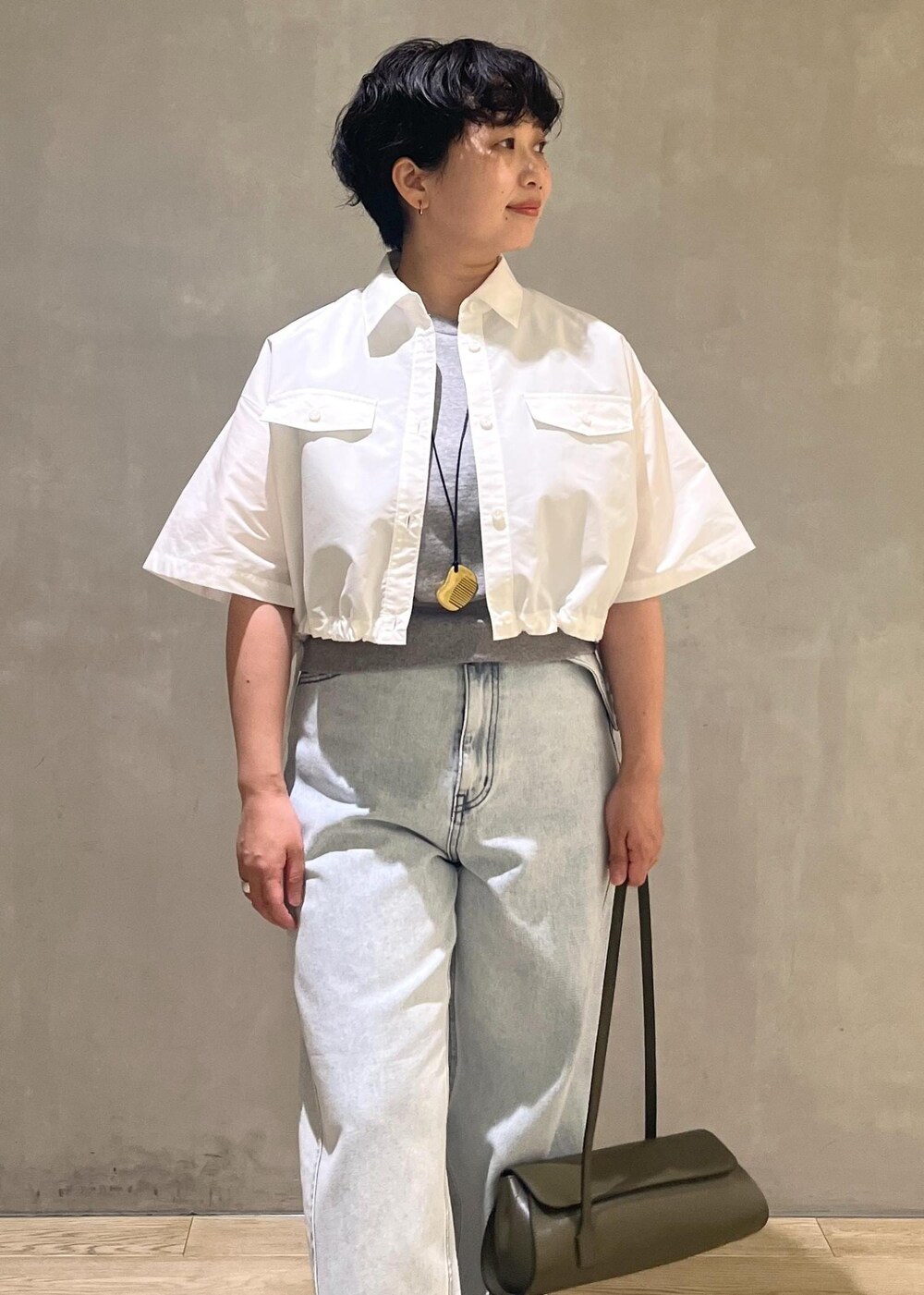 グレー系のTシャツ/カットソー、ブルー系のデニムパンツ、ホワイト系のシャツ/ブラウスを着用したレディースの夏コーディネートの4枚目の写真