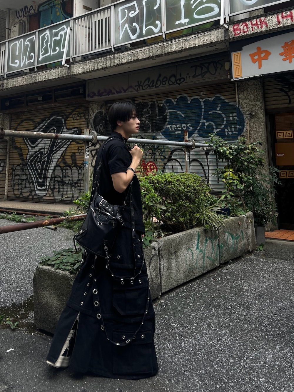 ブラック系のトップス、ブラック系のバッグ、ブラック系のスニーカーを着用したメンズの秋コーディネートの5枚目の写真