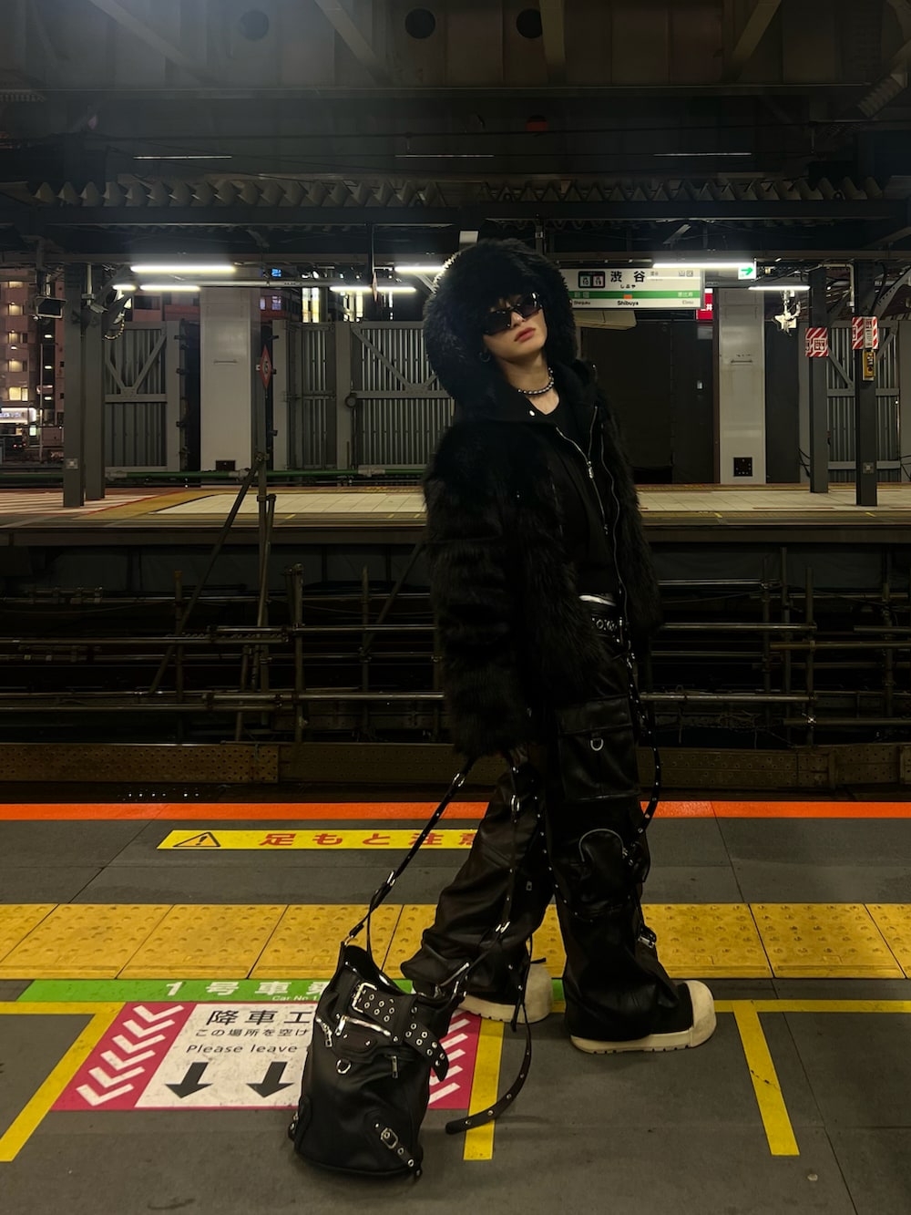 ブラック系のジャケット/アウター、ブラック系のバッグ、ブラック系のサングラスを着用したメンズの冬コーディネートの3枚目の写真