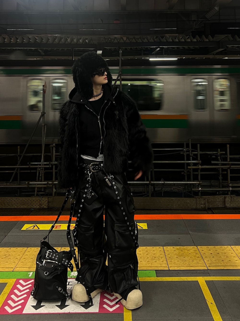 ブラック系のジャケット/アウター、ブラック系のバッグ、ブラック系のサングラスを着用したメンズの冬コーディネートの2枚目の写真