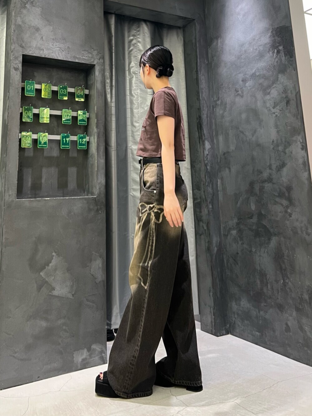 ブラック系のサンダル、ブラック系のデニムパンツ、ブラウン系のTシャツ/カットソーを着用したレディースの夏コーディネートの2枚目の写真