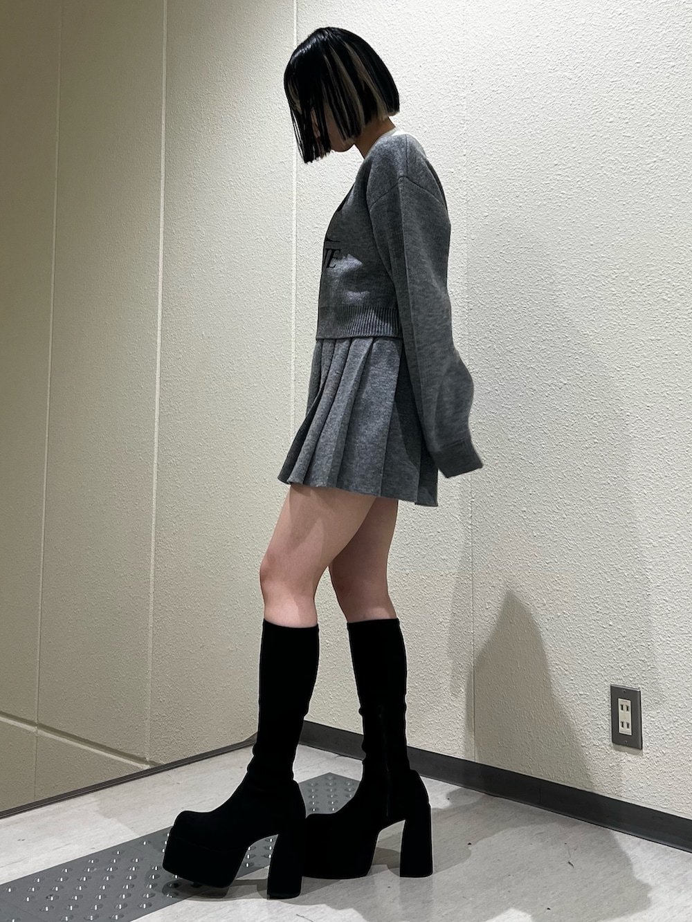 グレー系のスカート、グレー系のニット/セーター、その他のブーツを着用したレディースの冬コーディネートの2枚目の写真