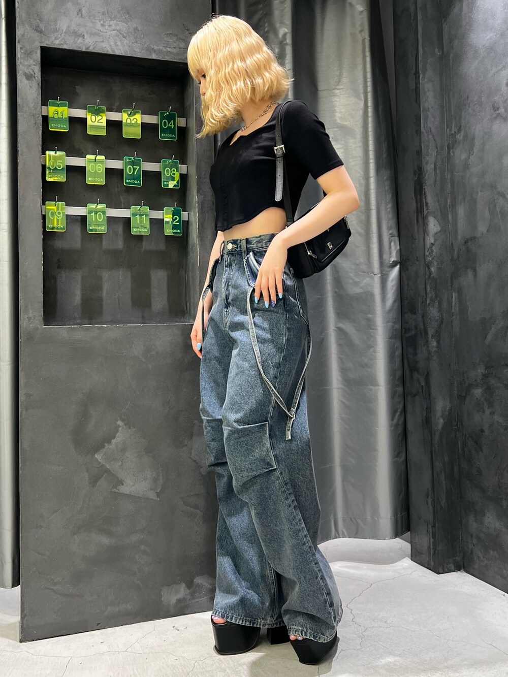 ブラック系のTシャツ/カットソー、ブラック系のショルダーバッグ、ブルー系のデニムパンツを着用したレディースの夏コーディネートの2枚目の写真