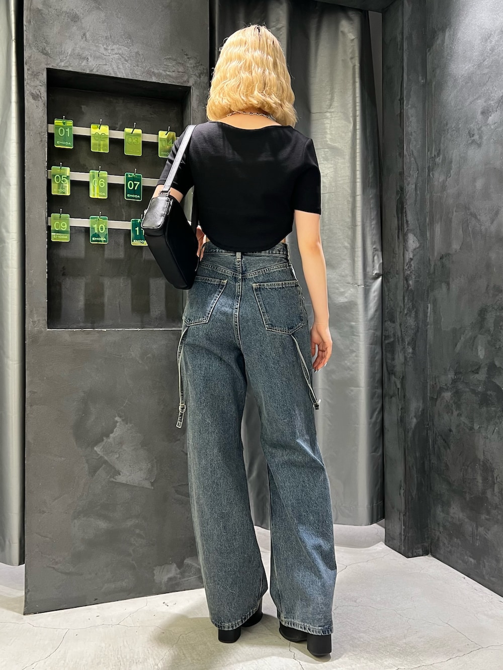 ブラック系のTシャツ/カットソー、ブラック系のショルダーバッグ、ブルー系のデニムパンツを着用したレディースの夏コーディネートの3枚目の写真