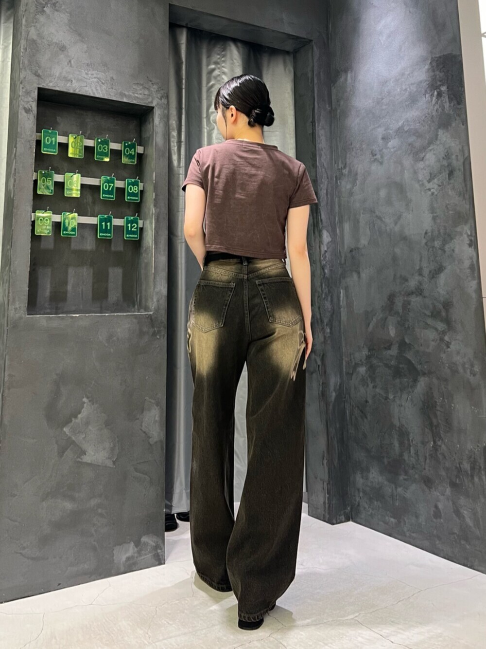 ブラック系のサンダル、ブラック系のデニムパンツ、ブラウン系のTシャツ/カットソーを着用したレディースの夏コーディネートの3枚目の写真