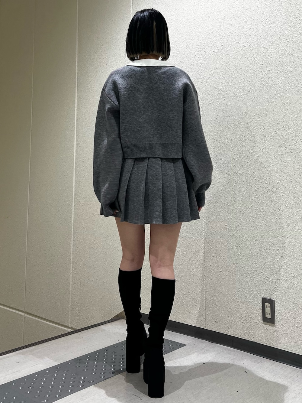 グレー系のスカート、グレー系のニット/セーター、その他のブーツを着用したレディースの冬コーディネートの3枚目の写真