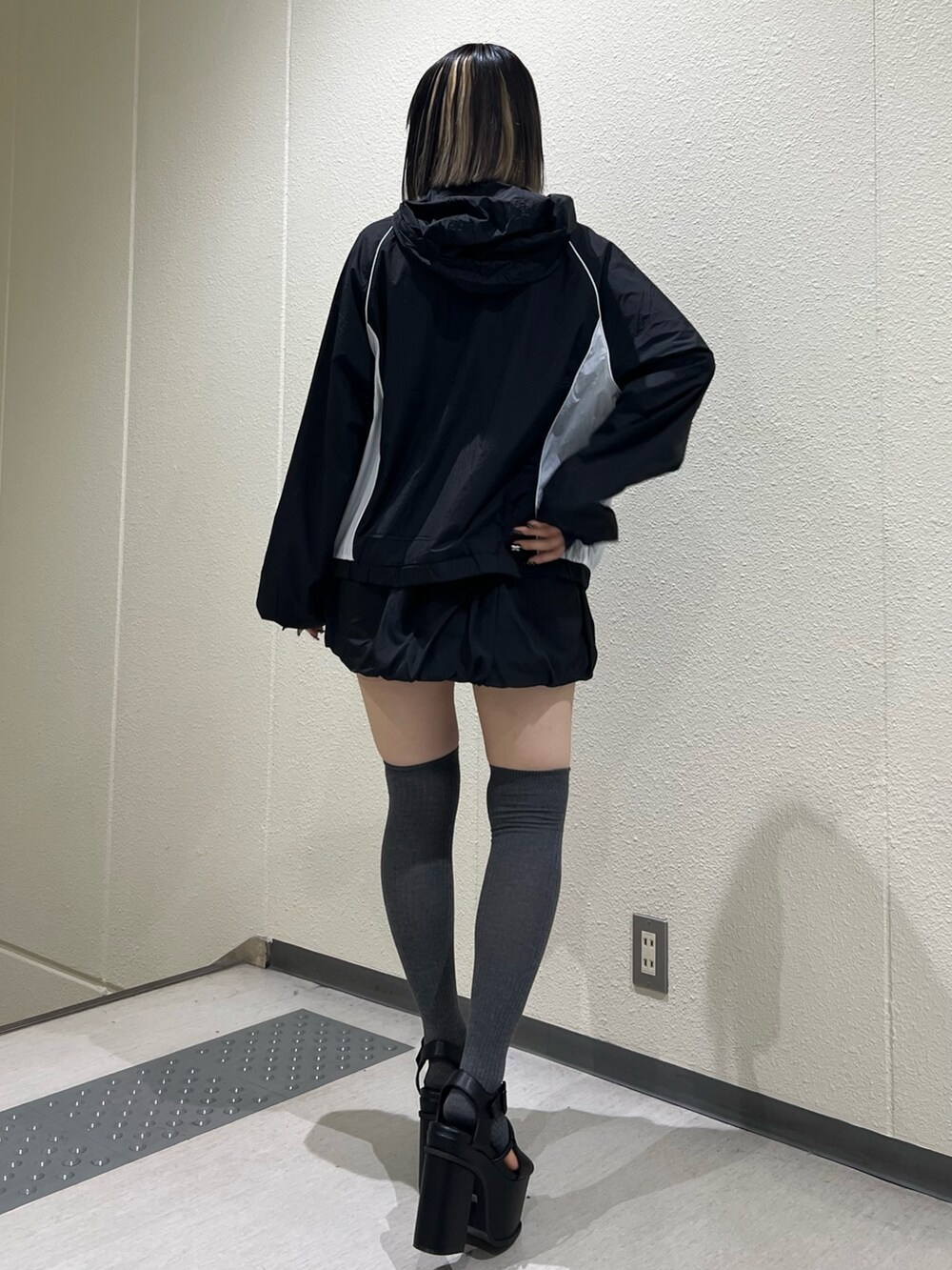 ブラック系のサンダル、ブラック系のブルゾン、ブラック系のスカートを着用したレディースの冬コーディネートの3枚目の写真