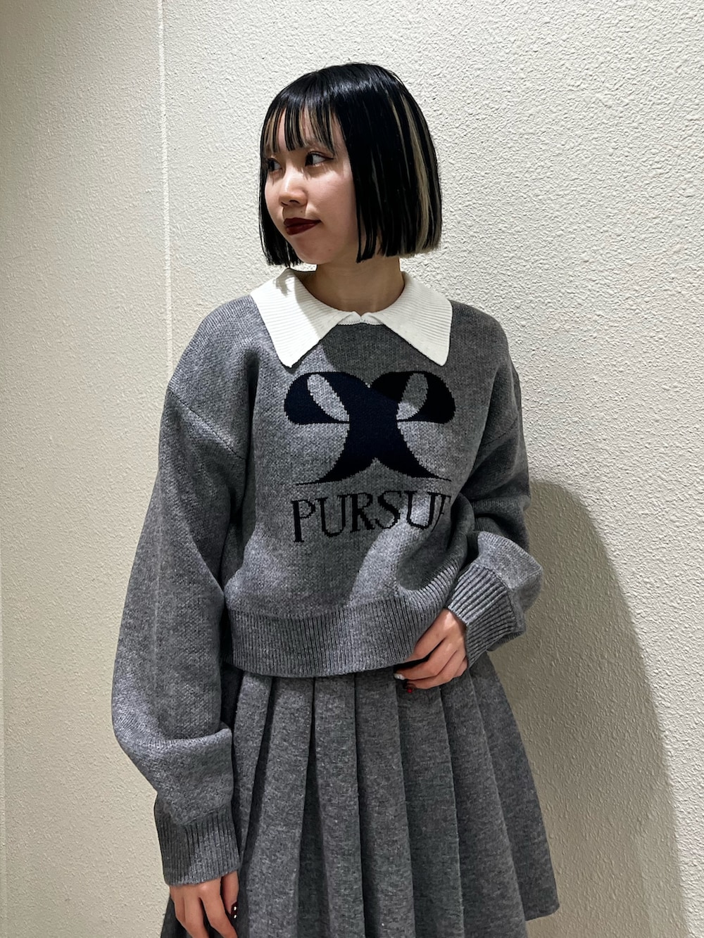 グレー系のスカート、グレー系のニット/セーター、その他のブーツを着用したレディースの冬コーディネートの4枚目の写真