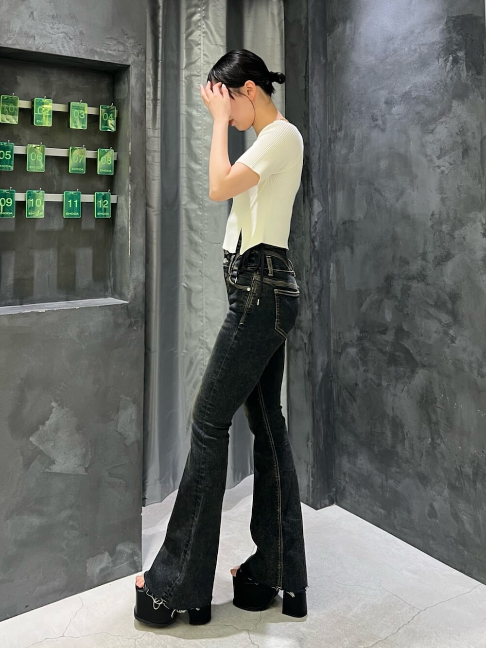 ブラック系のサンダル、ブルー系のデニムパンツ、ホワイト系のニット/セーターを着用したレディースの春コーディネートの2枚目の写真