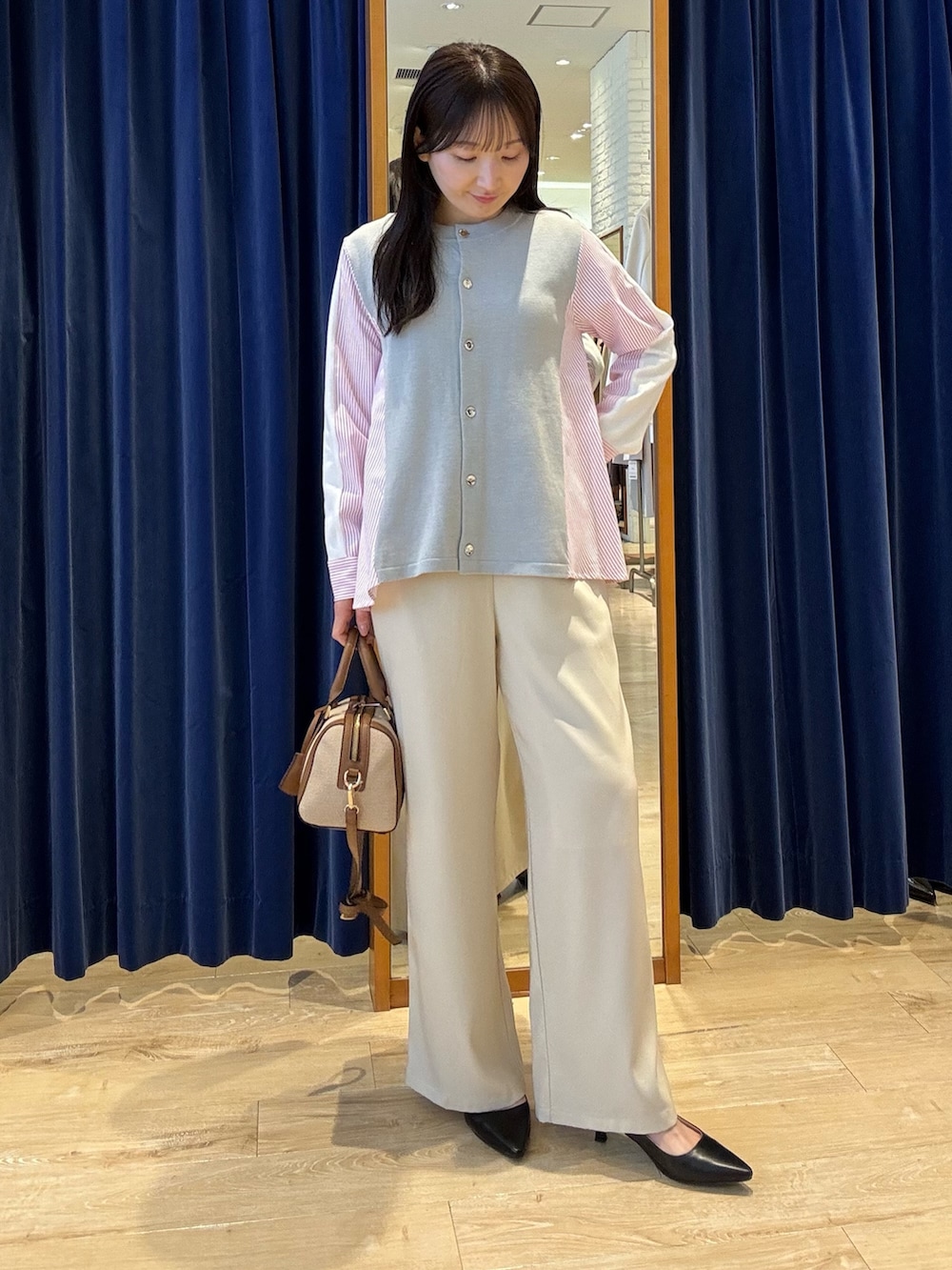 グレー系のニット/セーター、ホワイト系のその他パンツを着用したレディースの春コーディネートの2枚目の写真