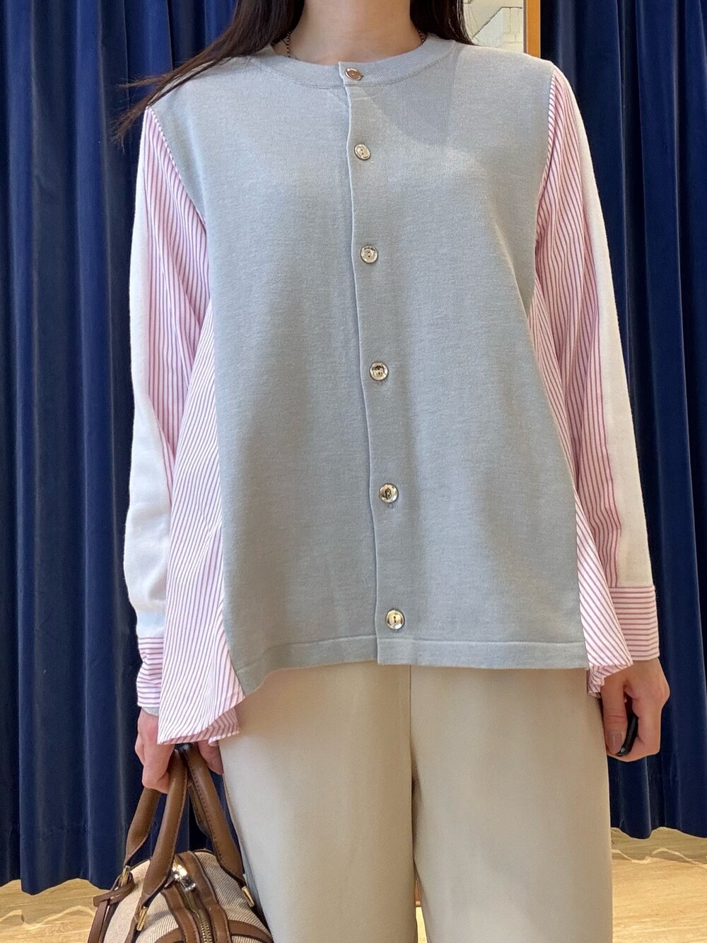 グレー系のニット/セーター、ホワイト系のその他パンツを着用したレディースの春コーディネートの10枚目の写真