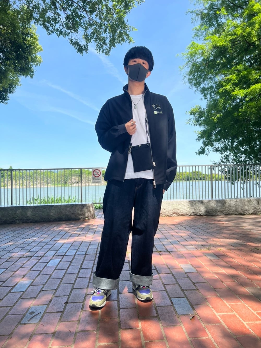 ブルー系のデニムパンツ、ブラック系のジャケット/アウター、その他のスニーカーを着用したメンズの春コーディネートの2枚目の写真