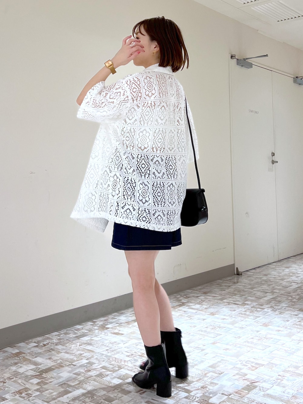 ブルー系のデニムスカート、ホワイト系のキャミソール、ホワイト系のテーラードジャケットを着用したレディースの夏コーディネートの2枚目の写真