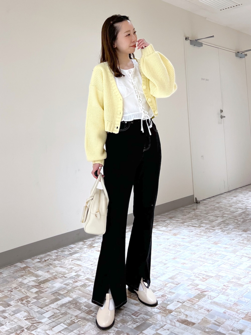 ホワイト系のボストンバッグ、ホワイト系のシャツ/ブラウス、イエロー系のカーディガン/ボレロを着用したレディースの冬コーディネートの2枚目の写真