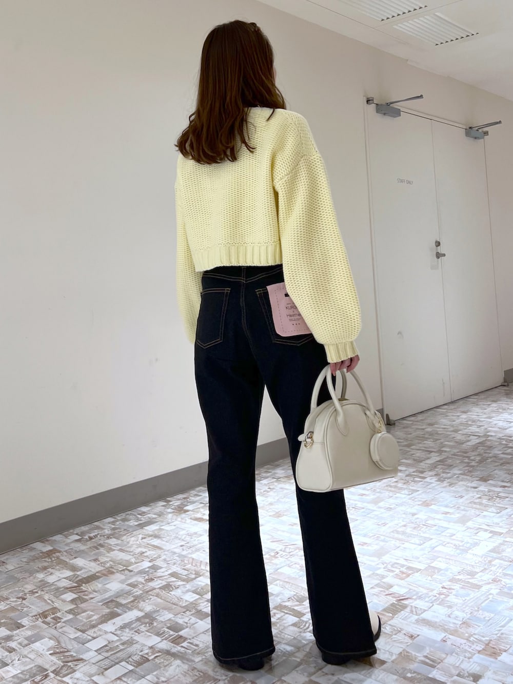 ホワイト系のボストンバッグ、ホワイト系のシャツ/ブラウス、イエロー系のカーディガン/ボレロを着用したレディースの冬コーディネートの3枚目の写真