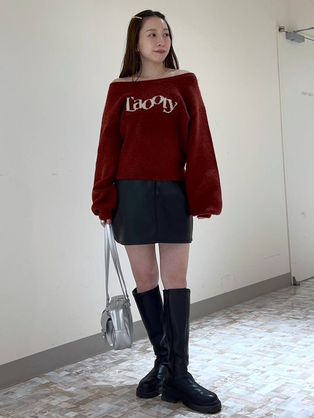 ブラック系のスカート、レッド系のニット/セーター、ブラック系のブーツを着用したレディースの秋コーディネートの2枚目の写真