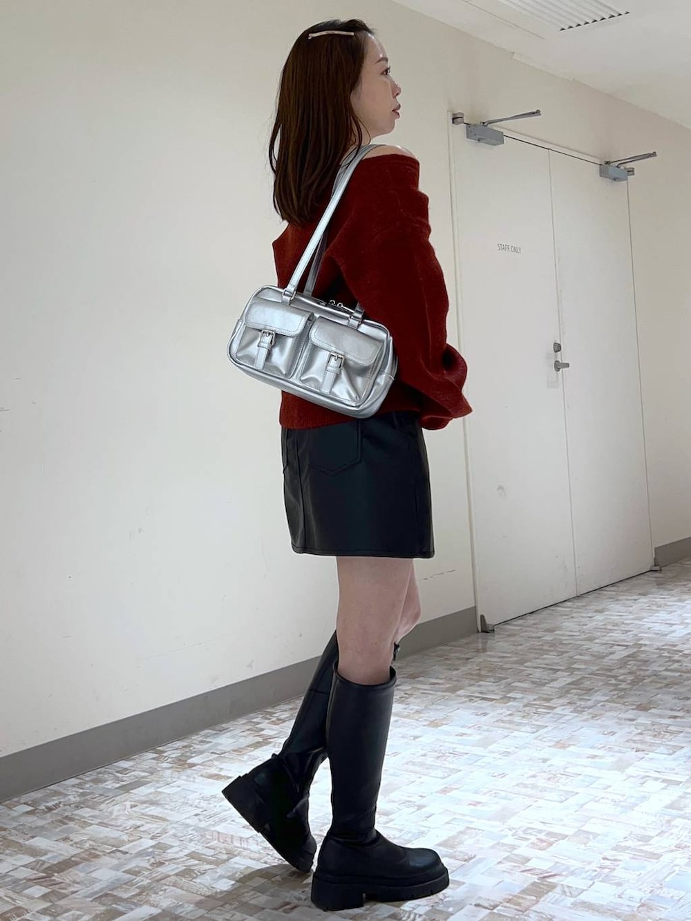 ブラック系のスカート、レッド系のニット/セーター、ブラック系のブーツを着用したレディースの秋コーディネートの3枚目の写真