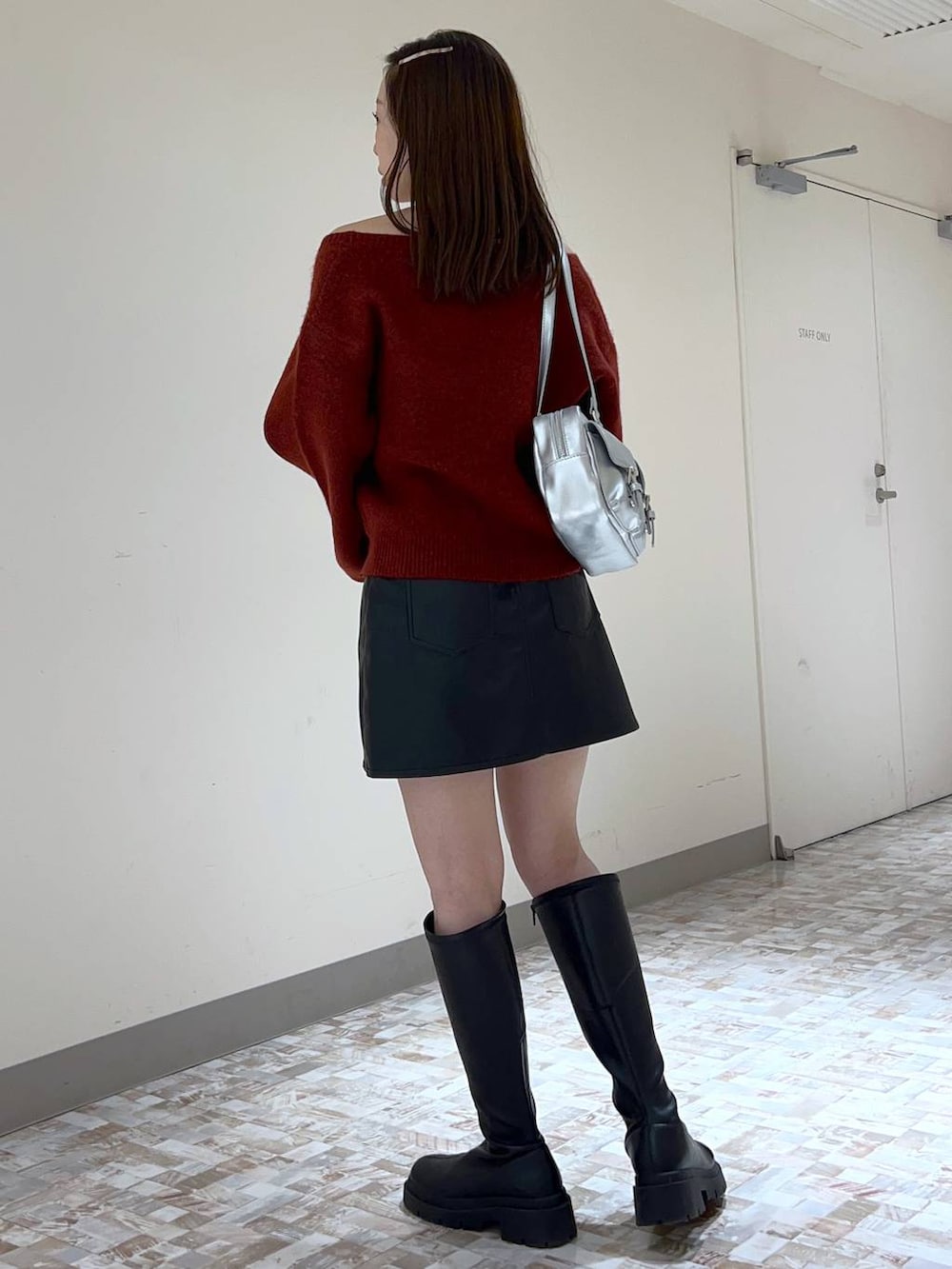 ブラック系のスカート、レッド系のニット/セーター、ブラック系のブーツを着用したレディースの秋コーディネートの4枚目の写真