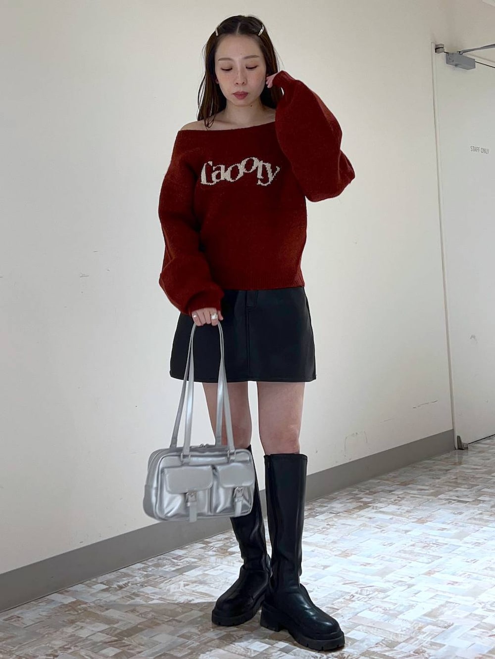 ブラック系のスカート、レッド系のニット/セーター、ブラック系のブーツを着用したレディースの秋コーディネートの5枚目の写真