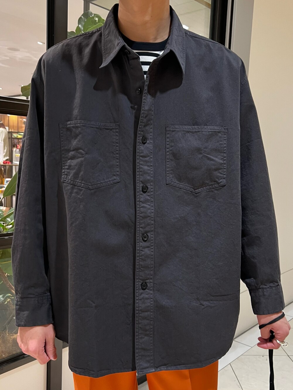 ブラック系のシャツ/ブラウス、ブラック系のハンドバッグ、オレンジ系のその他パンツを着用したメンズの冬コーディネートの3枚目の写真