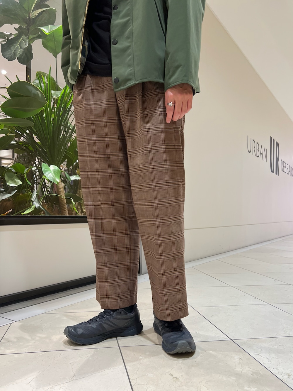 グリーン系のナイロンジャケット、ブラウン系のパンツ、グレー系のスニーカーを着用したメンズの秋コーディネートの5枚目の写真