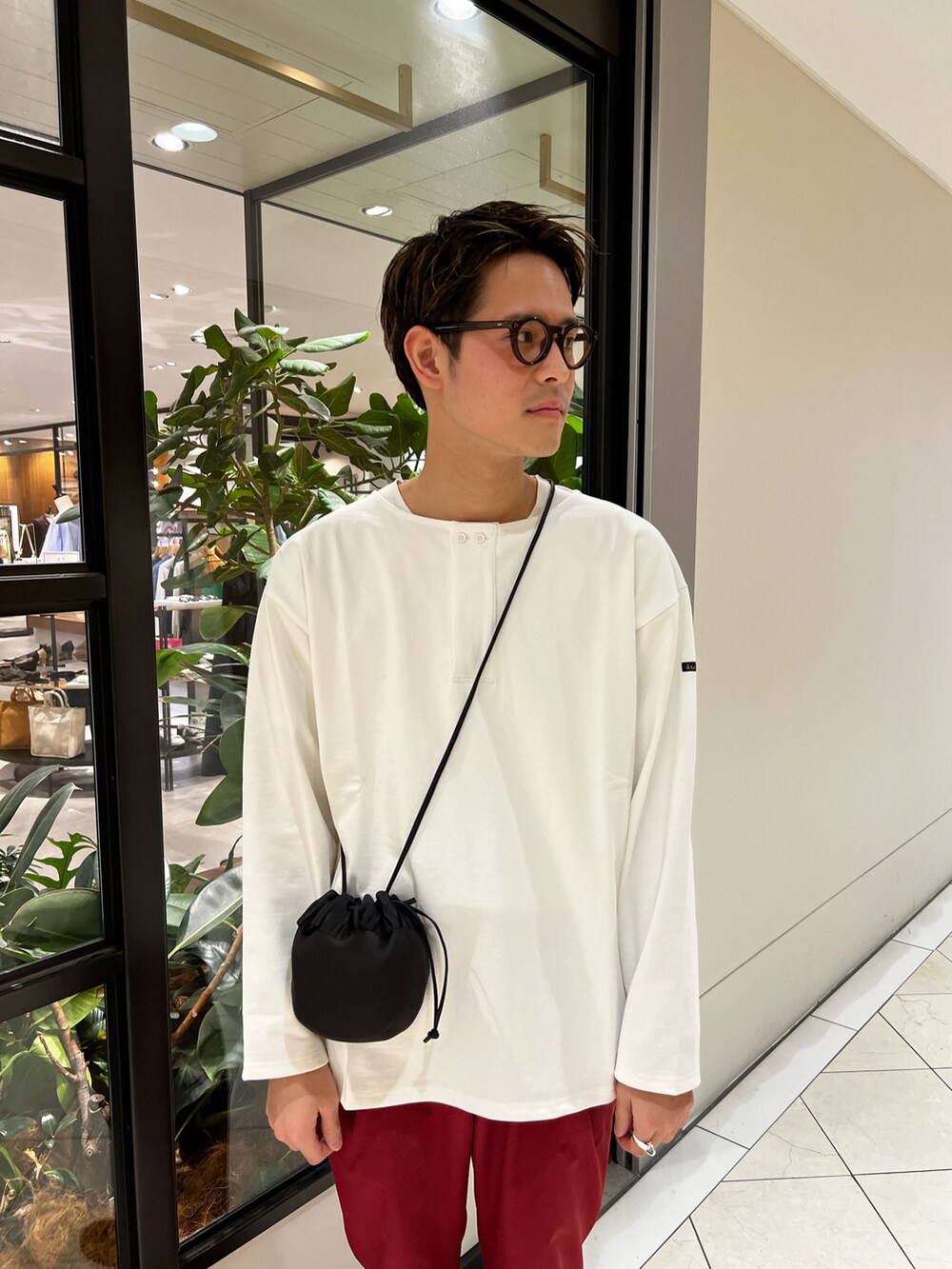 ホワイト系のTシャツ/カットソー、レッド系のその他パンツ、ブラック系のショルダーバッグを着用したメンズの春コーディネートの3枚目の写真