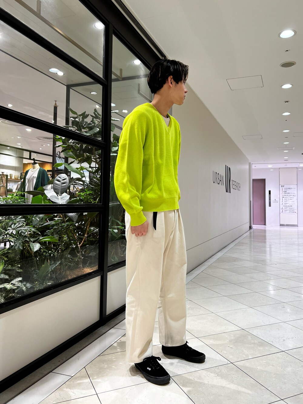 イエロー系のニット/セーター、ブルー系のブルゾン、ホワイト系のデニムパンツを着用したメンズの春コーディネートの2枚目の写真