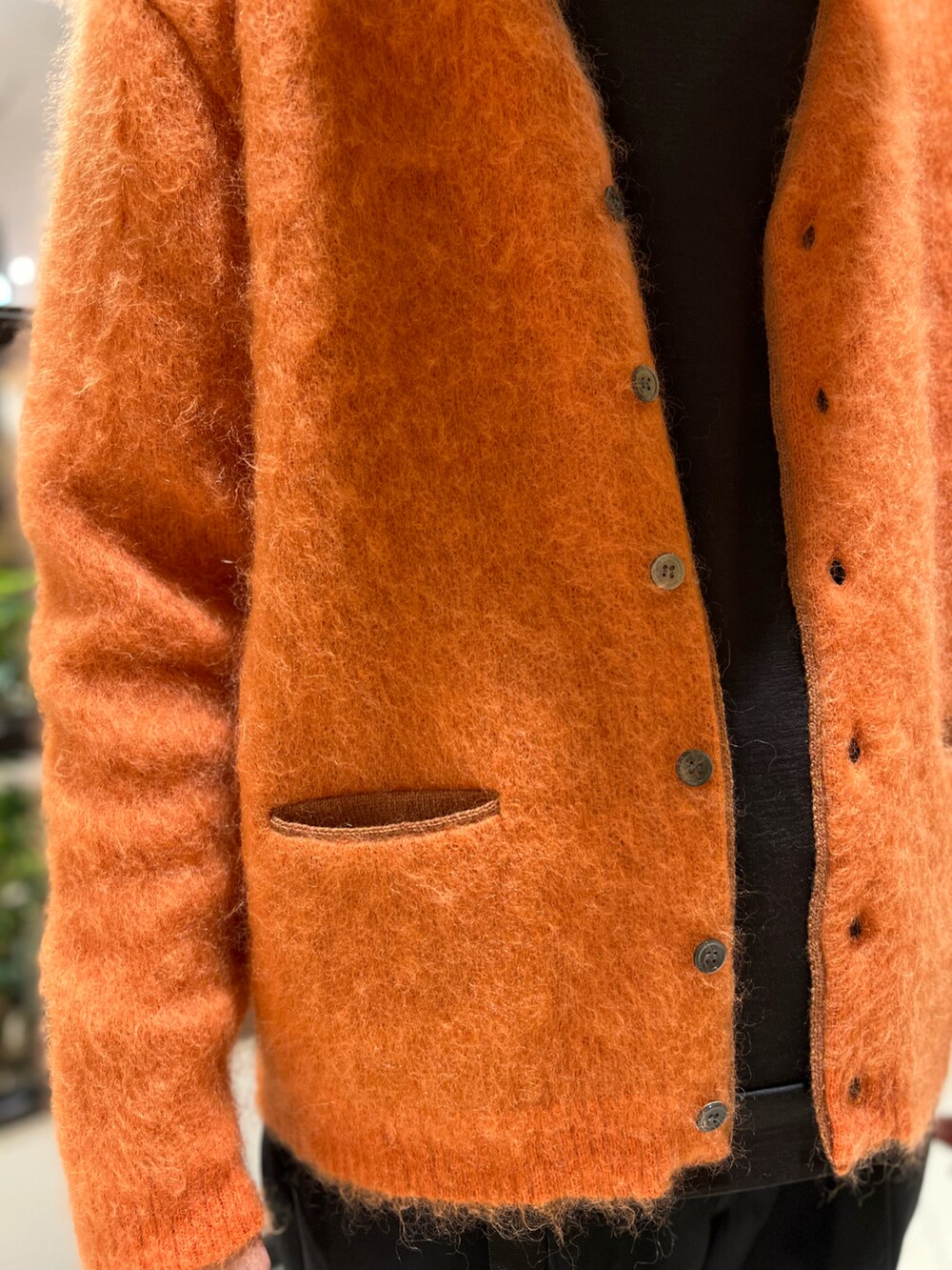 ブラック系のその他パンツ、オレンジ系のカーディガン/ボレロ、ブラウン系のスニーカーを着用したメンズの冬コーディネートの3枚目の写真