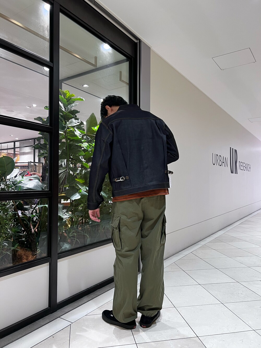 グリーン系のカーゴパンツ、ブラウン系のTシャツ/カットソー、ブルー系のデニムジャケットを着用したメンズの秋コーディネートの2枚目の写真