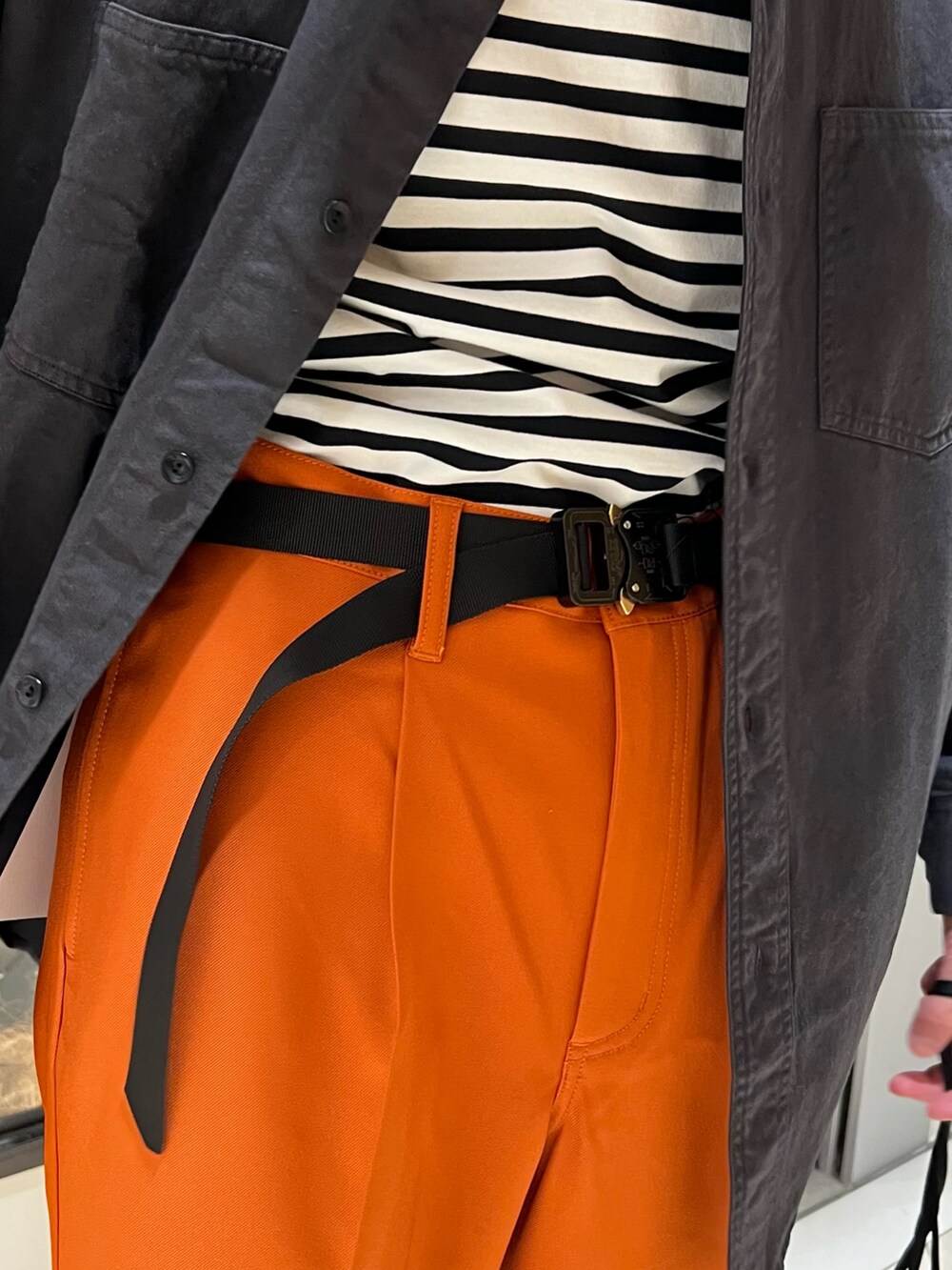 ブラック系のシャツ/ブラウス、ブラック系のハンドバッグ、オレンジ系のその他パンツを着用したメンズの冬コーディネートの4枚目の写真