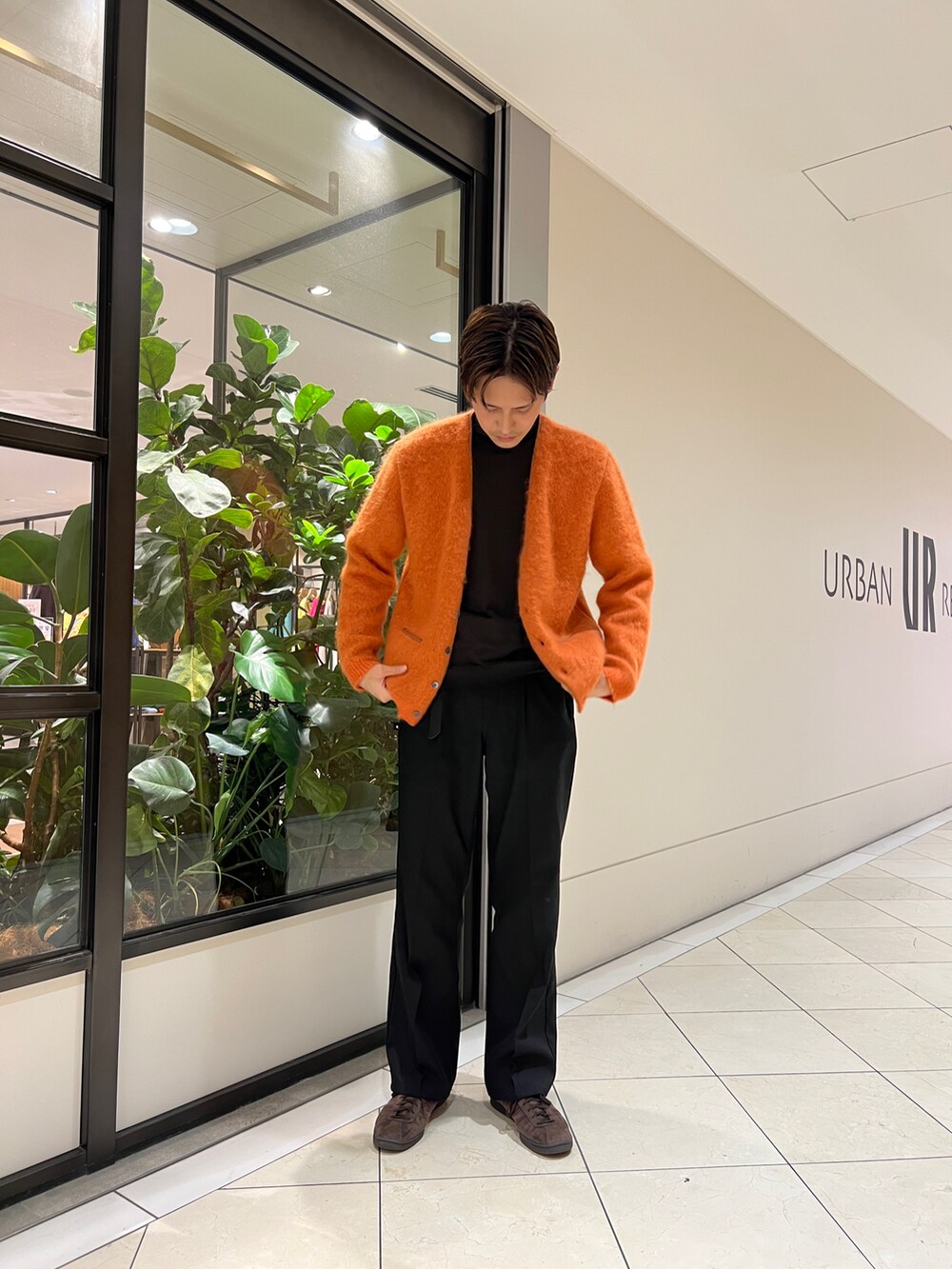 ブラック系のその他パンツ、オレンジ系のカーディガン/ボレロ、ブラウン系のスニーカーを着用したメンズの冬コーディネートの2枚目の写真