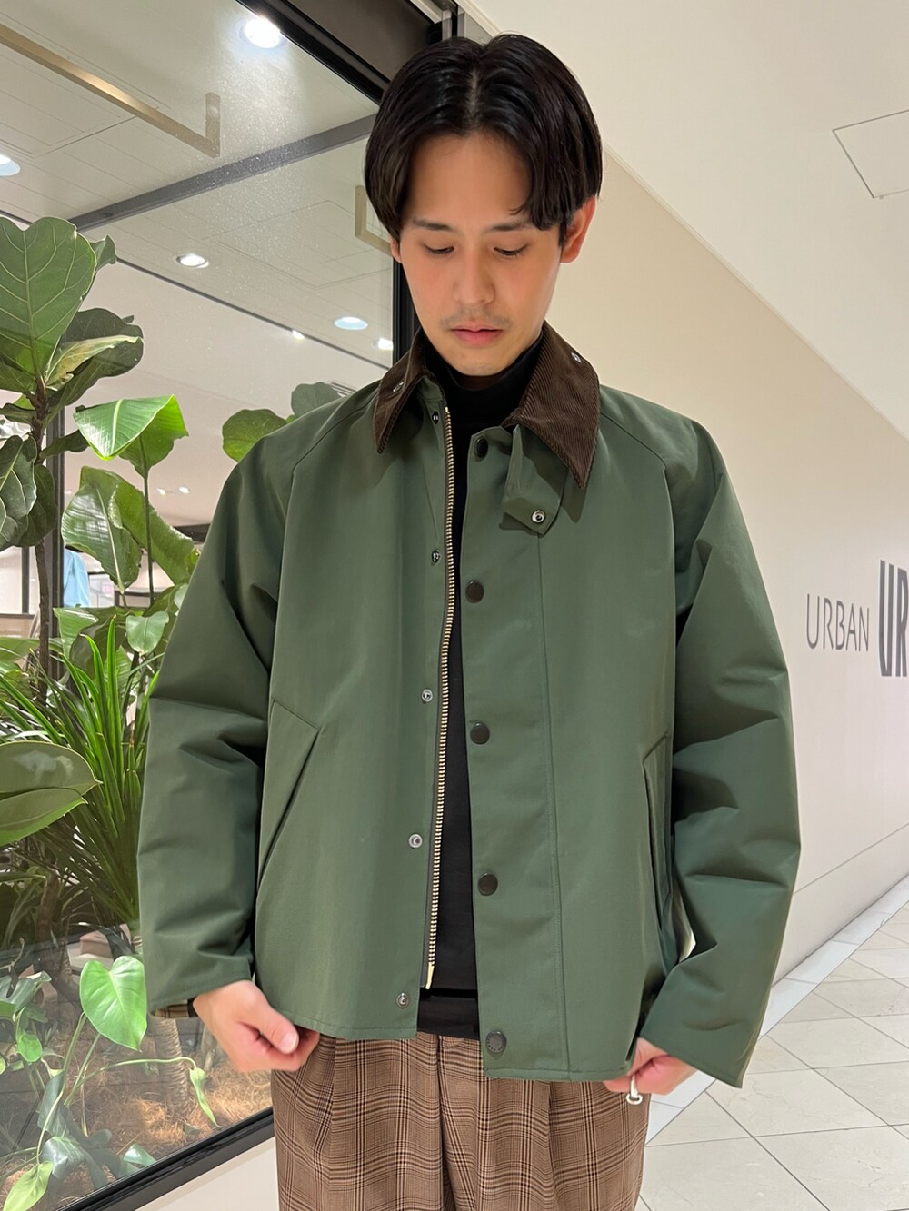 グリーン系のナイロンジャケット、ブラウン系のパンツ、グレー系のスニーカーを着用したメンズの秋コーディネートの4枚目の写真