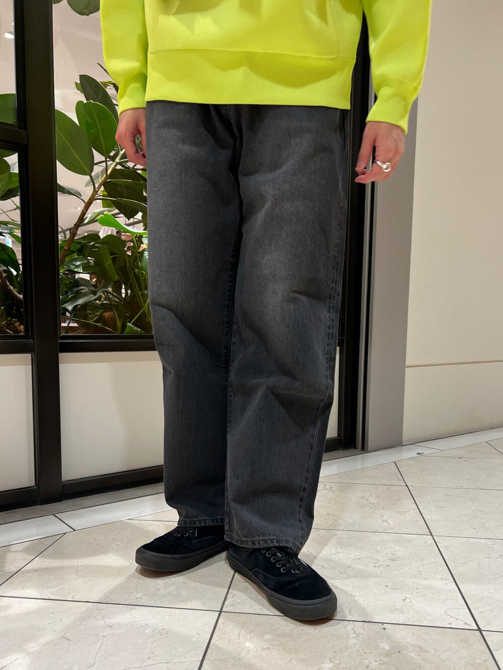 グリーン系のパーカー、ブラック系のショルダーバッグ、ブラック系のデニムパンツを着用したメンズの冬コーディネートの5枚目の写真