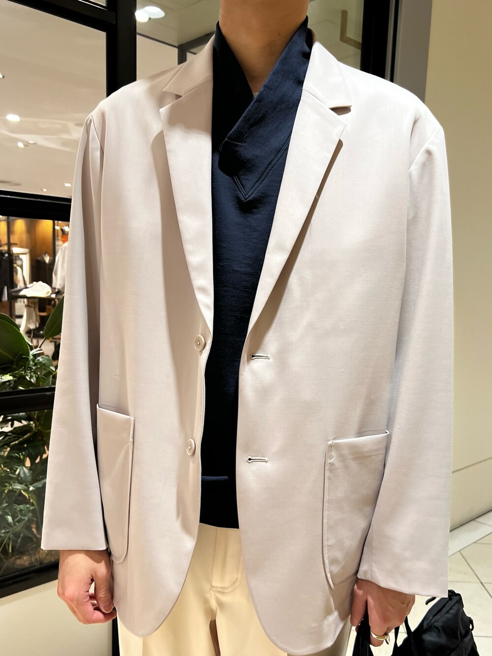 ブルー系のベスト、グレー系のその他アウター、ブラック系のトートバッグを着用したメンズの春コーディネートの4枚目の写真