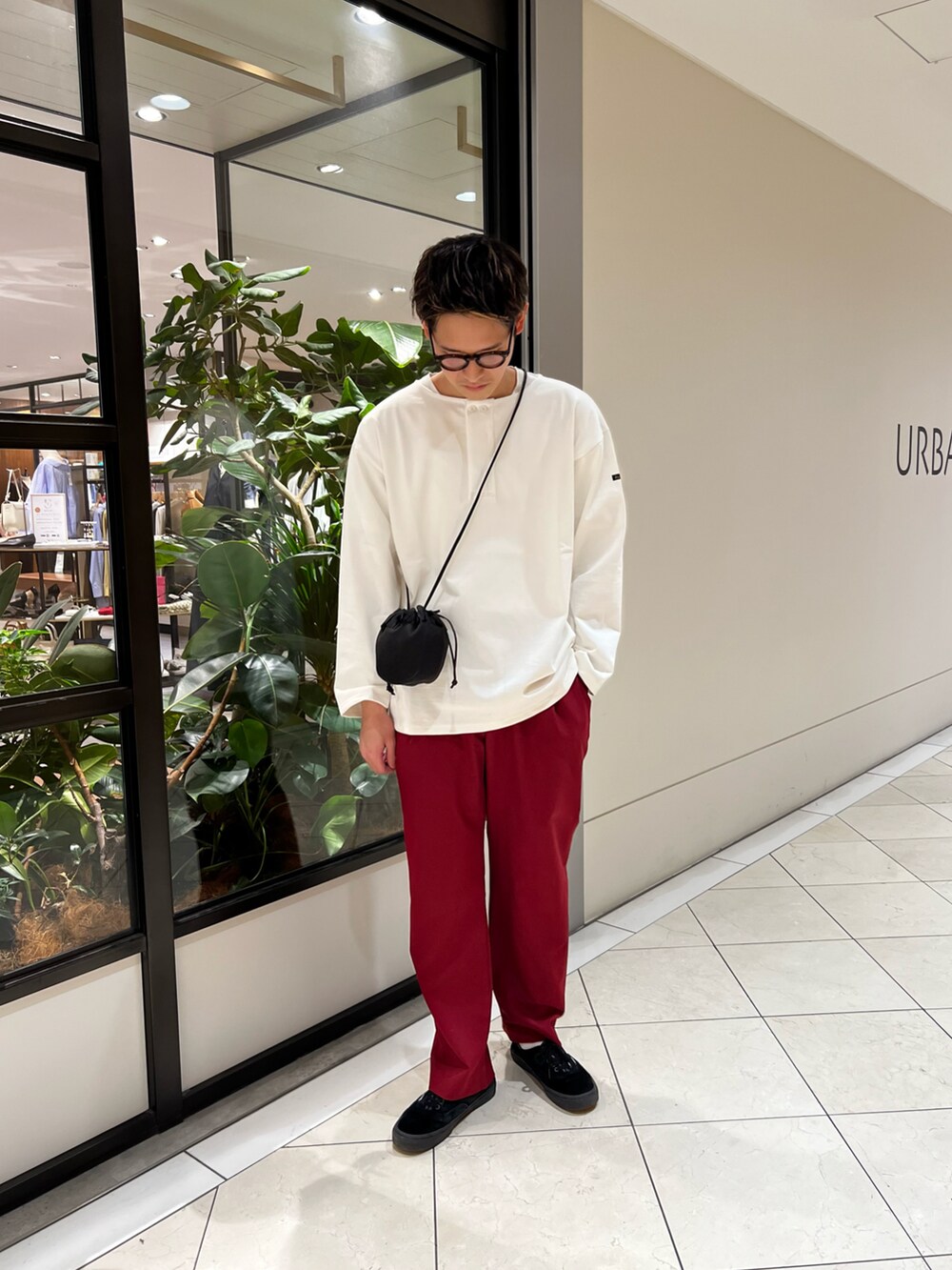 ホワイト系のTシャツ/カットソー、レッド系のその他パンツ、ブラック系のショルダーバッグを着用したメンズの春コーディネートの2枚目の写真