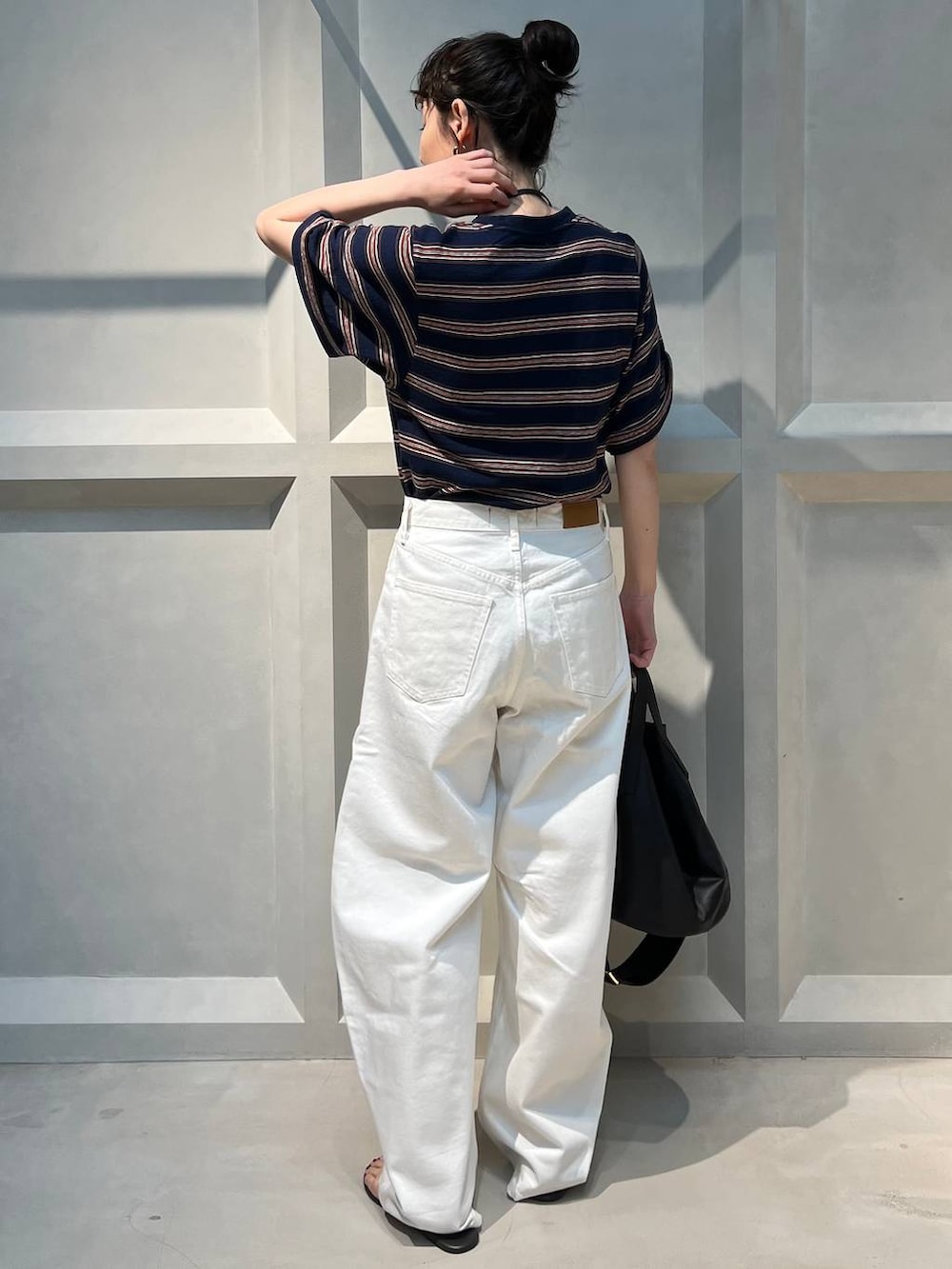 ホワイト系のデニムパンツ、ブルー系のTシャツ/カットソー、ブラック系のショルダーバッグを着用したレディースの夏コーディネートの3枚目の写真