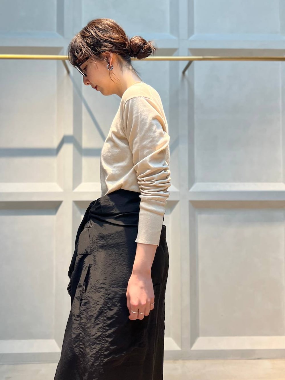 ホワイト系のニット/セーター、ブラック系のつなぎ/オールインワン、シルバー系のネックレスを着用したレディースの春コーディネートの6枚目の写真