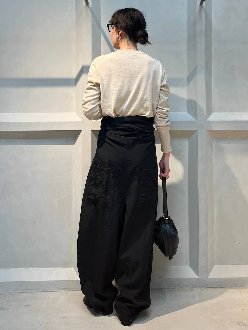 ホワイト系のニット/セーター、ブラック系のつなぎ/オールインワン、シルバー系のネックレスを着用したレディースの春コーディネートの3枚目の写真