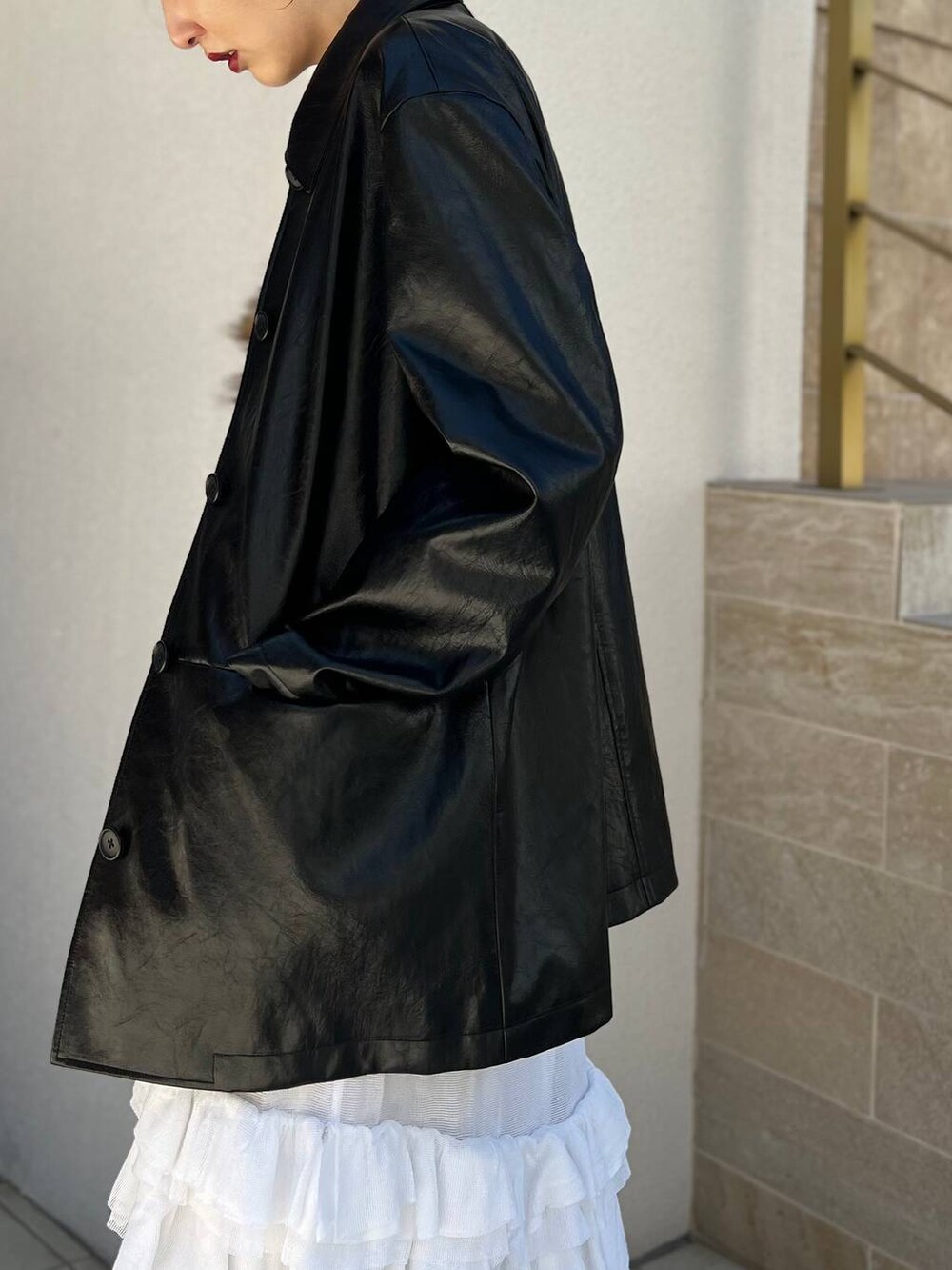 ホワイト系のタンクトップ、ホワイト系のスカート、ブラック系のブルゾンを着用したレディースの夏コーディネートの5枚目の写真