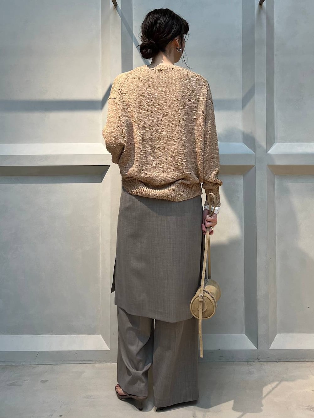 ホワイト系のTシャツ/カットソー、グレー系のその他パンツ、ベージュ系のニット/セーターを着用したレディースの春コーディネートの3枚目の写真