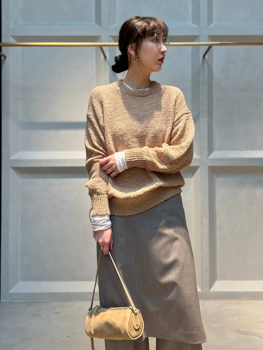 ホワイト系のTシャツ/カットソー、グレー系のその他パンツ、ベージュ系のニット/セーターを着用したレディースの春コーディネートの5枚目の写真