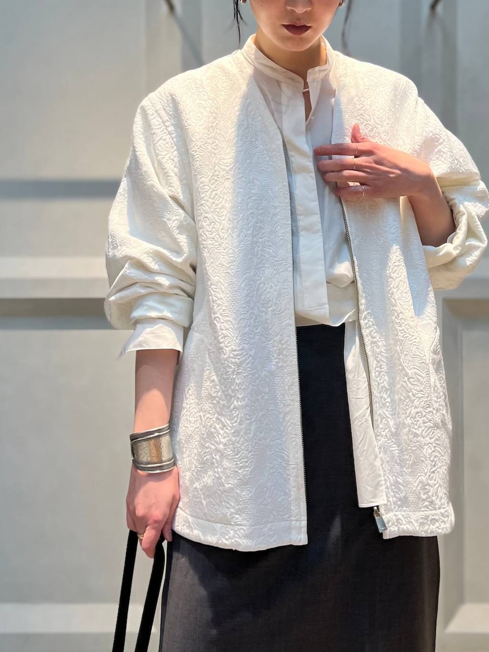 ホワイト系のシャツ/ブラウス、ホワイト系のブルゾン、グレー系のその他パンツを着用したレディースの冬コーディネートの7枚目の写真