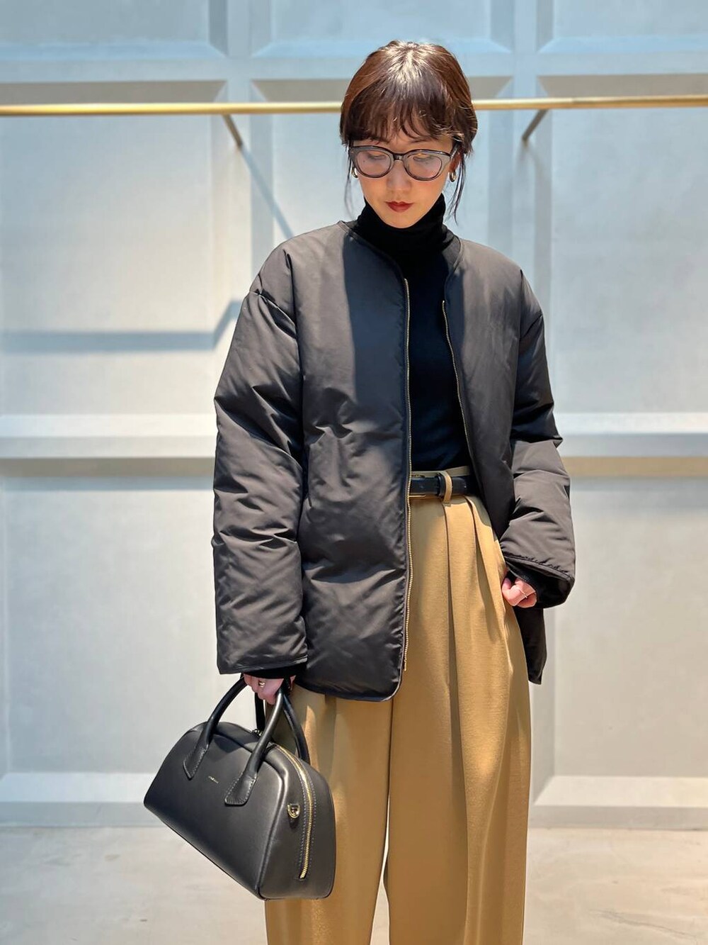 ブラック系のダウンジャケット/コート、ブラック系のニット/セーターを着用したレディースの冬コーディネートの5枚目の写真